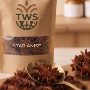 以下が含まれることがあります： 透明な窓が付いたスターアニスの茶色の紙袋で、「STAR ANISE」の文字が見えます。 金色のスプーンと木製のまな板にはスターアニスが入っています。 ブランド名「THREEWORLDSTORE」が上部にあります。