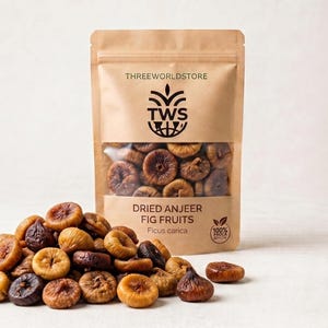 Może przedstawiać: Beżowa torebka stojąca z etykietą THREEWORLDSTORE i przezroczystym okienkiem ukazującym suszone brązowe figi. Tekst głosi DRIED ANJEER FIG FRUITS oraz Ficus carica. Stos tych samych suszonych brązowych fig jest ułożony przed torebką.