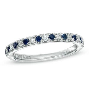 Könnte beinhalten: Ein silberner Ring mit abwechselnd runden, dunkelblauen und klaren Edelsteinen. Der Ring ist innen mit den Worten "A WANG LOVE" beschriftet. Der Ring ist vor einem weißen Hintergrund platziert.