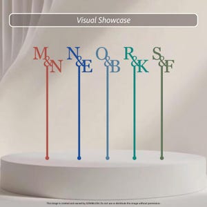 May include: Five thin, vertical cake toppers featuring letter pairs M&N, N&E, O&B, R&K, and S&F in red, blue, light blue, teal, and olive green. Each topper has a long, slender stem ending in a small circular base, displaying serif typography.