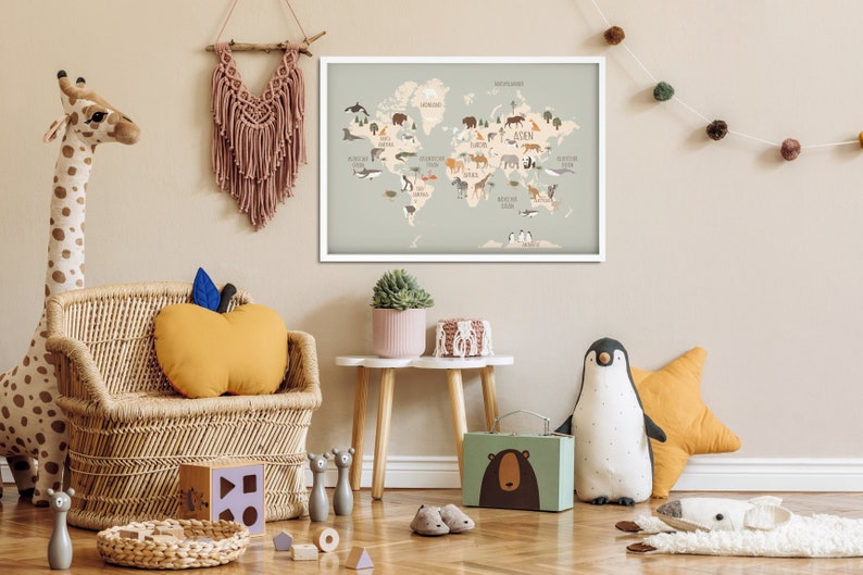 May include: A light blue world map with illustrations of animals from different continents. The map is framed in white and hanging on a light beige wall. The map is surrounded by various children's toys, including a stuffed giraffe, a stuffed penguin, and a wicker chair.