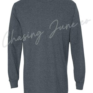 May include: Dark grey long-sleeved shirt with a crew neck and ribbed cuffs. The text "Chasing June co" is written in a cursive font across the front of the shirt.