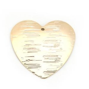 May include: A gold-colored heart-shaped pendant with a textured surface. The pendant has a small hole at the top for hanging. The heart is a simple, elegant design, suitable for jewelry making or crafting.