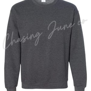 May include: A dark gray crewneck sweatshirt. The sweatshirt has long sleeves and a ribbed hem and cuffs. The text "Chasing June co" is written in a cursive font across the front of the sweatshirt.