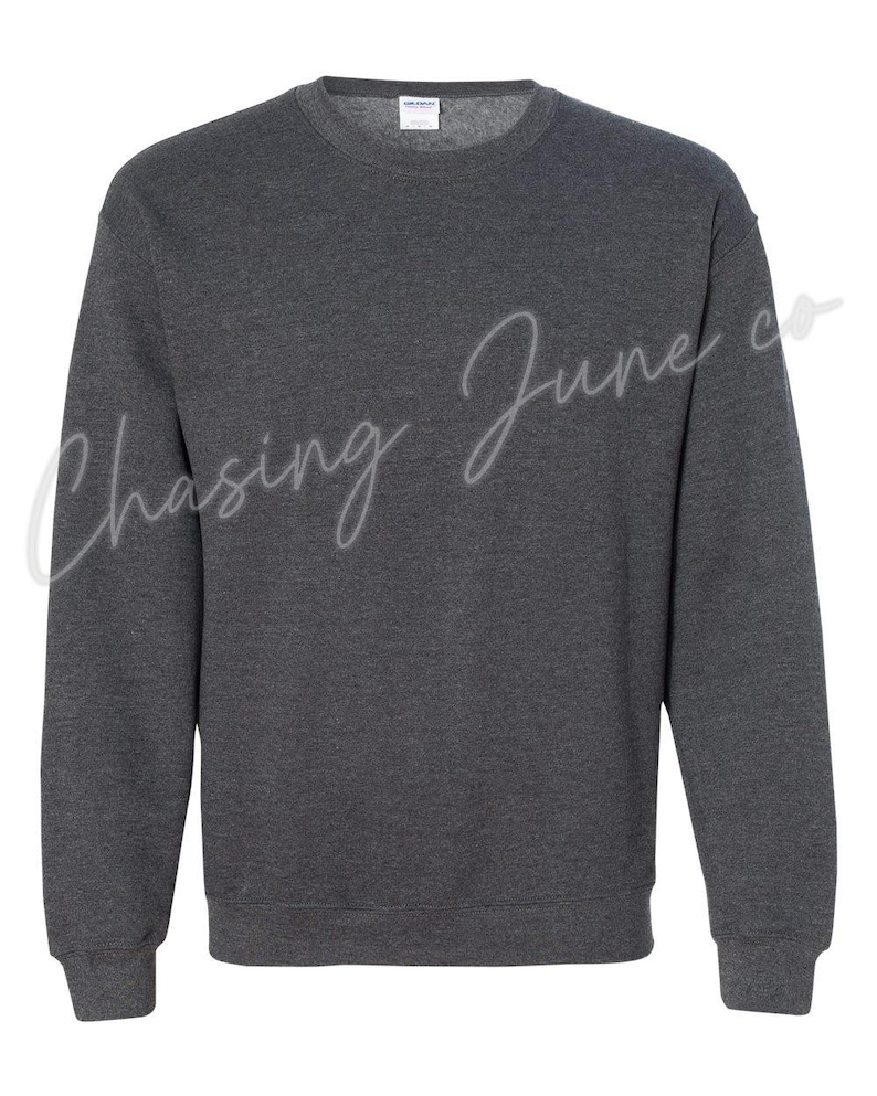 May include: A dark gray crewneck sweatshirt. The sweatshirt has long sleeves and a ribbed hem and cuffs. The text "Chasing June co" is written in a cursive font across the front of the sweatshirt.