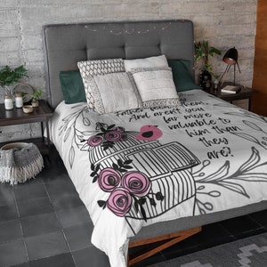 Puede incluir: Bedding blanco con un diseño de jaula de pájaros en blanco y negro y rosas rosas. La ropa de cama tiene el texto "Padre, creo en ti. ¿Y no eres mucho más valioso para Él que ellos?"