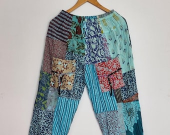 May include: Patchwork trousers featuring a variety of blue, teal, and red fabric panels with diverse floral and geometric patterns. These pants include an elastic waistband with a drawstring, two front pockets, and elasticized cuffs at the ankles.