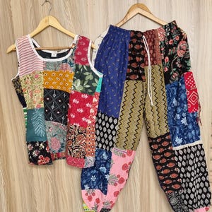 May include: A patchwork tank top and matching pants set. The top is sleeveless with a white trim and a variety of fabric patterns. The pants have an elastic waistband and drawstring, featuring a mix of floral, geometric, and abstract designs.