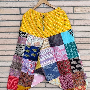 Könnte beinhalten: Patchwork-Hose mit einem gelben, gestreiften Bund und einer Vielzahl von bunten Stoffquadraten.