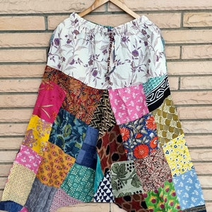 Puede incluir: Pantalones de patchwork con una parte superior de estampado floral. Los pantalones están hechos de telas de diferentes colores y tienen una cintura con cordón.