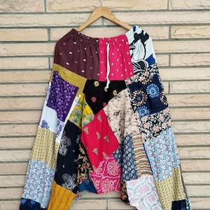 Könnte beinhalten: Patchwork-Hose mit einer Vielzahl von bunten floralen und geometrischen Mustern. Die Hose hat einen Kordelzugbund und eine lockere, fließende Passform.