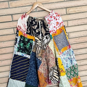 Könnte beinhalten: Ein Patchwork-Rock mit einer Vielzahl von bunten floralen, geometrischen und tierischen Mustern. Der Rock hat einen Kordelzug in der Taille und ist aus einem weichen, leichten Material gefertigt.