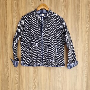 May include: A blue and white patterned jacket with a mandarin collar and long sleeves. The jacket has a button closure and two pockets.