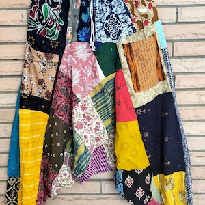 Pode incluir: Calças de patchwork com uma variedade de padrões florais coloridos. As calças têm uma cintura com cordão e um caimento solto e fluido.