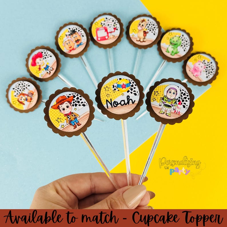 Puede incluir: Una colecci&oacute;n de adornos redondos para cupcakes con varios personajes de dibujos animados de Toy Story, incluidos Woody, Buzz Lightyear y Rex. Cada adorno tiene un borde festoneado marr&oacute;n y un palito de pl&aacute;stico transparente. Uno muestra el nombre Noah.