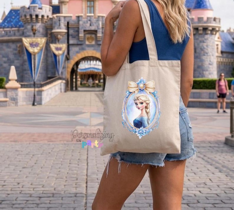 Peut inclure: Un sac fourre-tout en toile beige avec une impression graphique repr&eacute;sentant un personnage blond en robe bleue dans un cadre ovale bleu clair orn&eacute;, surmont&eacute; d'un n&oelig;ud cr&egrave;me. Le texte Personalizing Ur Party est imprim&eacute; en bleu et rose.