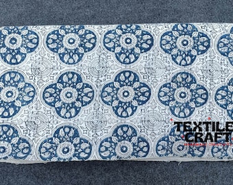 Puede incluir: Tela blanca con un patrón floral azul y blanco. La tela tiene un patrón repetitivo de flores azules con centros blancos y hojas blancas. La tela es texturizada y tiene un tacto ligeramente áspero. La tela está etiquetada como "Textiles Craft".