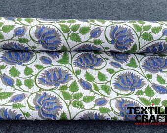 Könnte beinhalten: Weißer Baumwollstoff mit einem blauen und grünen Blumendruck. Der Stoff ist in der Hälfte gefaltet und der Druck ist auf beiden Seiten sichtbar. Der Stoff wird "Kantha" genannt und ist eine traditionelle indische handgenähte Steppdecke.