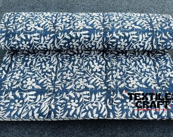 Puede incluir: Una colcha kantha azul y blanca con un patrón floral. La colcha está doblada por la mitad y el texto "TEXTILES CRAFT" es visible en la esquina inferior derecha.