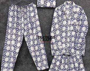 May include: A navy blue pajama set with a white floral design. The set comprises long trousers, a button-down shirt, and shorts. A matching pouch is also included. The pajamas are displayed on hangers against a grey background.