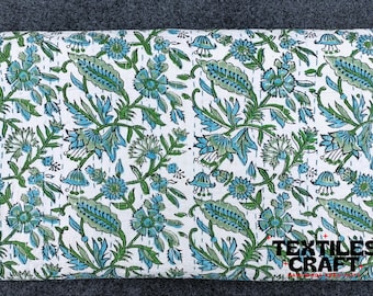 May include: White cotton fabric with a blue and green floral print. The fabric is quilted and has a subtle sheen. The fabric is labeled "Textiles Craft".