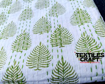 May include: White fabric with a repeating pattern of green stylized leaves. The fabric has a quilted texture and the text "TEXTILES CRAFT" is printed in the bottom right corner.