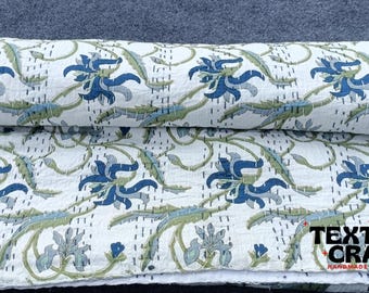May include: White kantha quilt with a floral pattern in shades of blue and green. The quilt is folded in half and has a "TEXTILES CRAFT" label on the bottom.
