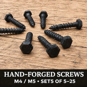 May include: A collection of black, hand-forged screws with hexagonal heads and threaded shanks. The text at the bottom reads HAND-FORGED SCREWS M4 / M5 • SET5 OF 5-25. These metal fasteners are arranged in a circular pattern on a wooden surface.
