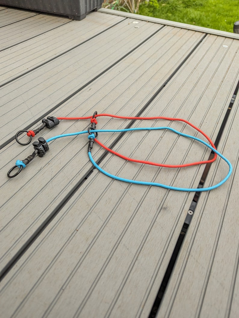 May include: Two leashes with black metal clips and swivels. One leash is red and the other is blue.