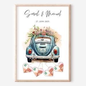 Puede incluir: Impresión enmarcada que presenta un coche azul vintage adornado con flores, con los nombres "Sarah & Manuel" y la fecha "27. JUNI 2025". Decoraciones en forma de corazón hechas de moneda están unidas al coche.