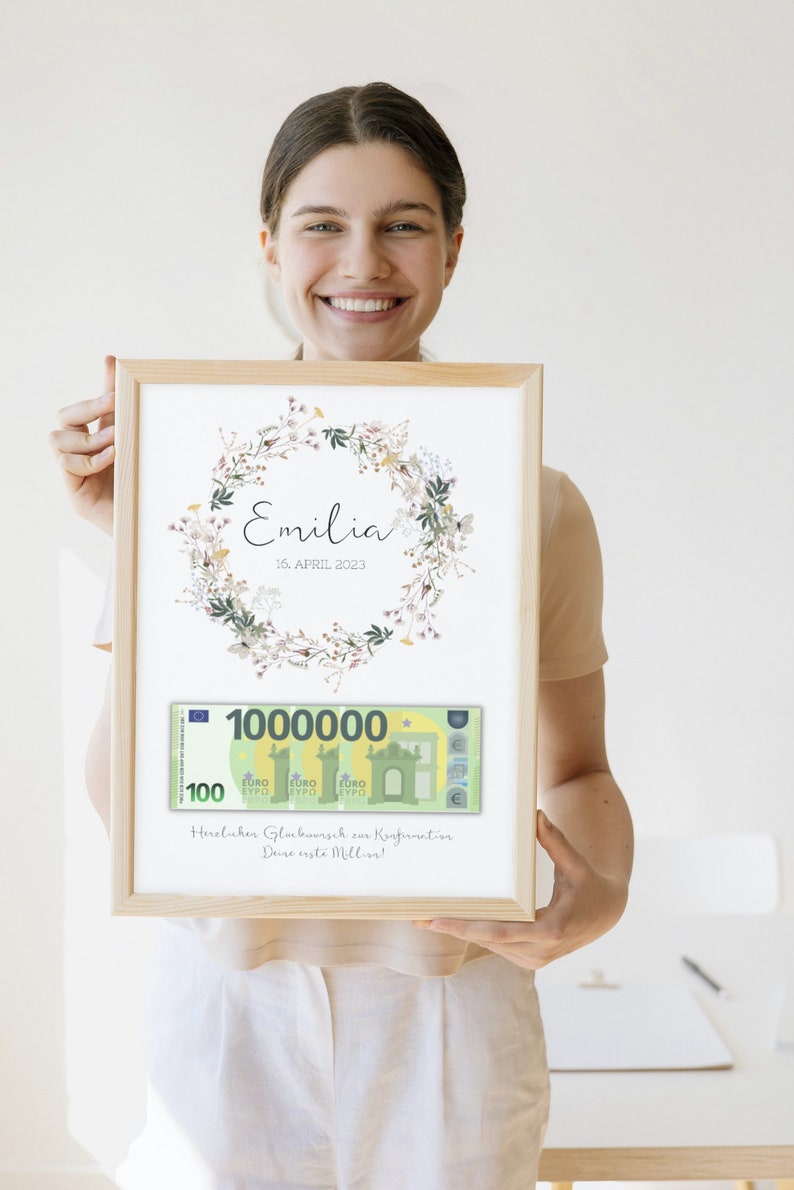 May include: A framed print with a floral wreath and the name "Emilia" and the date "16. APRIL 2023". A mock-up of a 100 euro bill with the number "1000000" is below the wreath. The text "Heraluher Glumbuunsch zur Konfirmation Deine erste Million!" is below the bill.