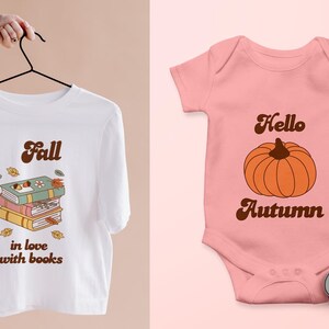 May include: Two shirts with fall-themed designs. A white t-shirt with a stack of books and the text "Fall in love with books". A pink baby onesie with a pumpkin and the text "Hello Autumn".
