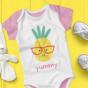 May include: A white baby onesie with pink trim and short sleeves. The onesie has a yellow pineapple with a red smiling face and red glasses. The text "yummy" is printed below the pineapple.