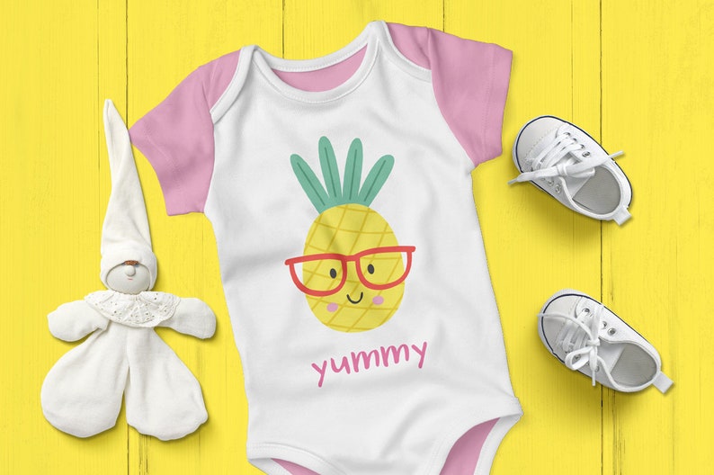May include: A white baby onesie with pink trim and short sleeves. The onesie has a yellow pineapple with a red smiling face and red glasses. The text "yummy" is printed below the pineapple.