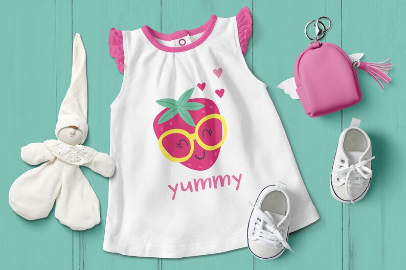 May include: White sleeveless baby onesie with pink trim and a strawberry graphic. The strawberry has a yellow face with sunglasses and the text "yummy" is printed below.