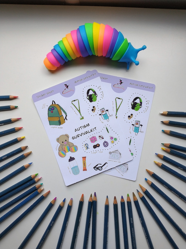 May include: A set of two sticker sheets with colorful illustrations of items that can be helpful for people with autism. The sticker sheets are titled "Autism Survival Kit" and "Sticker Sheet". The sheets are surrounded by a circle of colored pencils.