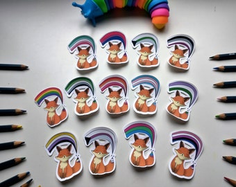 May include: Twelve fox stickers with different pride flags. Each sticker features a cartoon fox with a rainbow, bisexual, transgender, non-binary, pansexual, lesbian, genderfluid, asexual, intersex, and polyamorous pride flag.