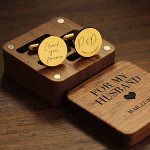 May include: A wooden box with a heart-shaped design and the text "For My Husband" and "Mar 1.2.20". The box contains two gold cufflinks, one with the text "I loved you forever" and the other with the text "P&D May 10.2023".