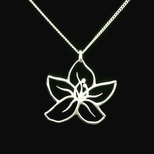 Op de afbeelding: Een zilveren ketting met een delicate bloemhanger. De bloem is uit het metaal gesneden, waardoor een delicaat en ingewikkeld ontwerp ontstaat.
