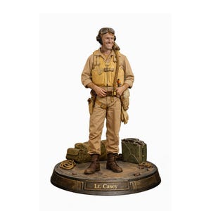 May include: A detailed figurine of a smiling man in a vintage aviator uniform, complete with goggles, a flight jacket, and a utility belt. The figure stands on a circular base with the name "Lt. Casey" inscribed. Accessories include a duffel bag, a metal box, and rope.