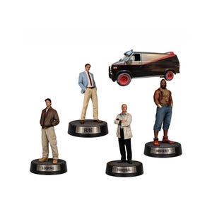 Könnte beinhalten: Eine Sammlung von Figuren mit Charakteren und einem Van aus einer beliebten Fernsehserie der 1980er Jahre. Die Figuren umfassen Looping, Fute, Hannibal und Mister T, jeweils auf einer schwarzen Basis mit ihrem Namen. Der Van ist schwarz und silber mit roten Rädern.