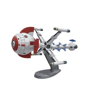 Puede incluir: Maqueta de nave espacial blanca y roja. La nave espacial tiene una cabina redonda, alas y propulsores. Está montada sobre un soporte gris, mostrando un diseño futurista.