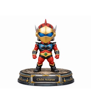 Op de afbeelding: Een Chibi Actarus-beeldje. De figuur is rood, zwart en goudkleurig, met een blauw vizier en een gouden helm. Het staat op een ronde basis met de tekst "Chibi Actarus".