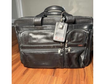 Maletín bandolera para portátil TUMI Alpha de piel negra, expandible, clásico.