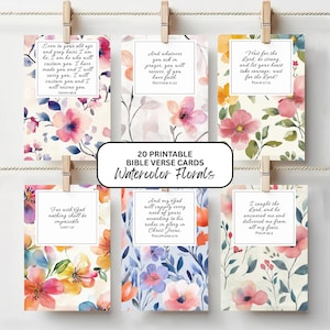 May include: Six rectangular cards featuring watercolor floral patterns and Bible verses, suspended by wooden clips. The cards display text including Isaiah 46:4, Matthew 21:22, Psalm 27:14, Luke 1:37, Philippians 4:19, and Psalm 34:4, with a central label reading 20 PRINTABLE BIBLE VERSE CARDS Watercolor Florals.