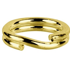 May include: A gold-coloured split ring, a type of jewellery finding. The ring is made of a shiny, metallic material and has a double-loop design. The split ring is a small, circular component used in jewellery making.
