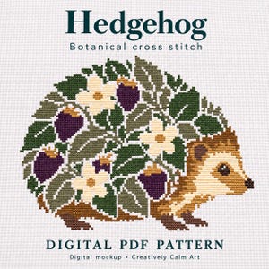 Könnte beinhalten: Ein Kreuzstichmuster mit einem Igel, dessen Rücken mit grünen Blättern, weißen Blüten und violetten Beeren bedeckt ist. Der Text lautet Hedgehog Botanical cross stitch und DIGITAL PDF PATTERN auf einem weißen Stoffhintergrund mit Gittermuster.