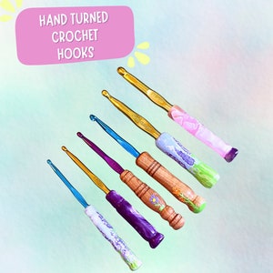 May include: Set of six hand-turned crochet hooks with wooden handles. The hooks are decorated with floral designs and come in a variety of colors, including pink, blue, purple, and gold.
