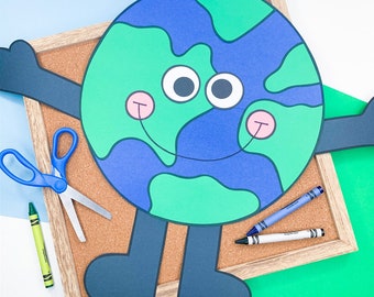 Puede incluir: Una manualidad de papel de una Tierra sonriente con continentes azules y verdes, brazos y piernas negros y ojos blancos. La Tierra está en un tablero de corcho con lápices de colores y tijeras.