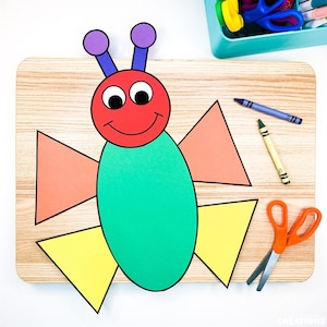May include: A colourful paper craft butterfly made from different shapes. The butterfly has a red head with eyes and a smile, a green oval body, orange wings, and yellow accents.